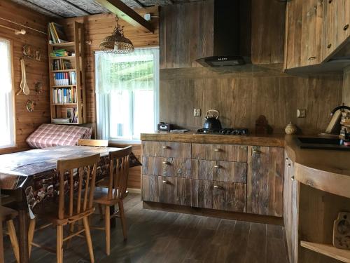 a kitchen with wooden cabinets and a table in a room at KTA TARPAN Podlaski Dom in Narewka