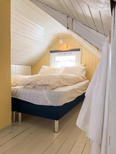 a bed in a tiny house with a window at Modern house 5 bedrooms 2 baths sentral in Bodø
