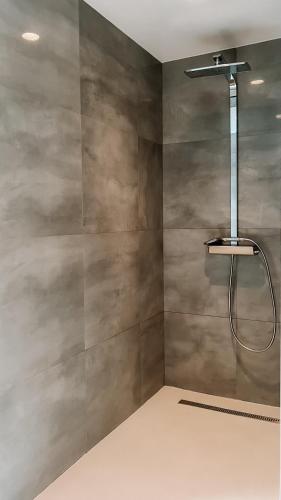 a shower in a bathroom with a gray wall at Modern house 5 bedrooms 2 baths sentral in Bodø