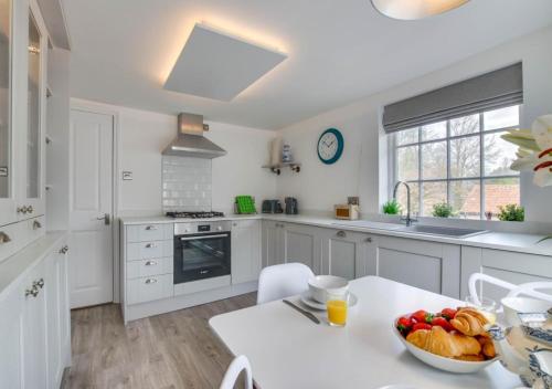 a kitchen with a table with a bowl of fruit on it at The Keep - Framlingham in Framlingham