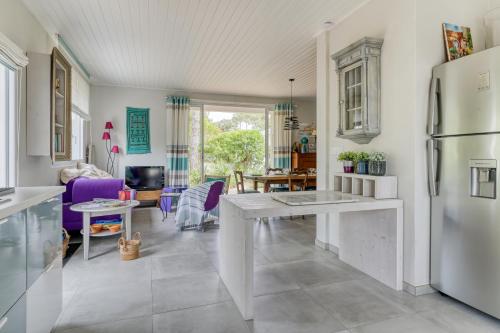 une cuisine avec un réfrigérateur blanc et une table dans l'établissement Maison de famille spacieuse à 1 min de la plage à pied, 2 chambres, à La Tranche-sur-Mer