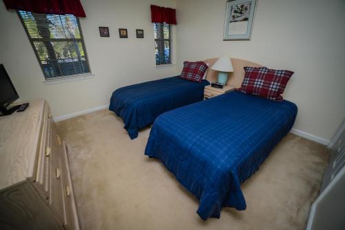 a bedroom with two beds with blue covers in it at Litchfield Beach & Golf Resort in Pawleys Island