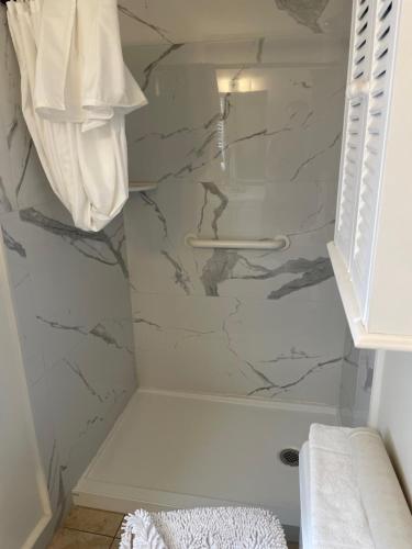 a bathroom with a shower with a marble wall at Venice Beach Villas in Venice