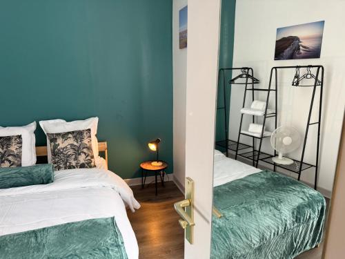 deux lits dans une chambre aux murs bleus dans l'établissement L'Appart Élevé Idéalement situé, à Boulogne-sur-Mer