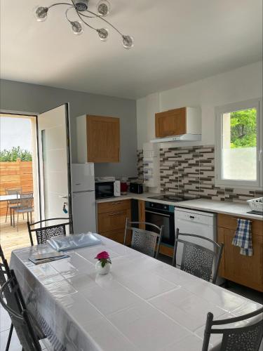 a kitchen with a table with a white tablecloth on it at Gîtes de Chaum in Chaum