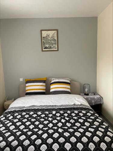 a bed with a black and white comforter in a bedroom at Gîtes de Chaum in Chaum