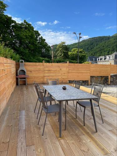a patio with a table and chairs on a wooden deck at Gîtes de Chaum in Chaum