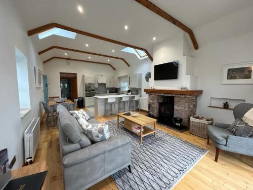 a living room with a couch and a fireplace at The Cottage at Ashbrook - Charming Country Cottage near Belfast in Belfast