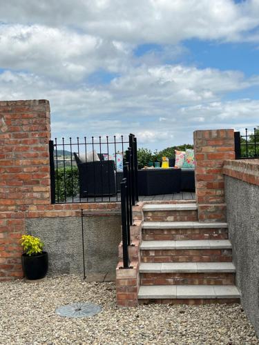 a set of stairs leading to a patio with a couch at The Cottage at Ashbrook - Charming Country Cottage near Belfast in Belfast