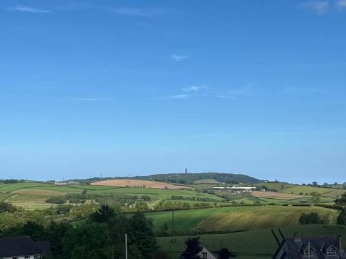 a view of a green field with a plane in the sky at The Cottage at Ashbrook - Charming Country Cottage near Belfast in Belfast