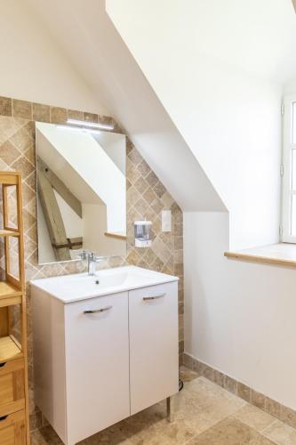 une salle de bain avec un lavabo blanc et un miroir dans l'établissement Château de Conon gîte l'ecurie, à Cellettes