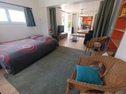 une chambre avec un lit et un salon dans l'établissement Maison zen, à Saint-Simon-de-Bordes