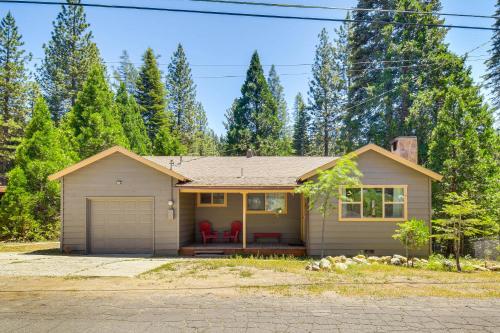 a house with a garage and trees in the background at Cozy Retreat with Deck about 2 Mi to Pinecrest Lake! in Strawberry