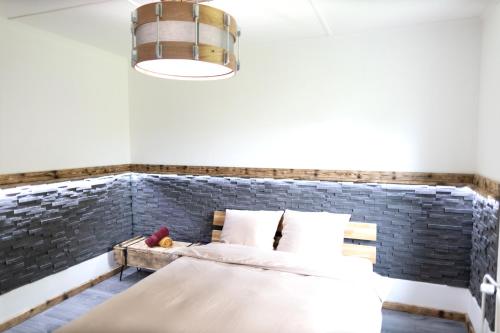 a bedroom with a bed and a brick wall at L'Air de Musique in Lajoux