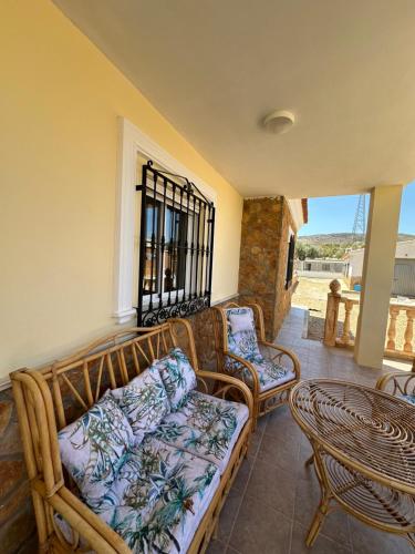 a living room with a couch and chairs and a table at Casa Rural El Pomelo in Zurgena