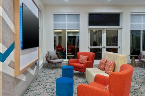 a lobby with chairs and a flat screen tv at Hilton Garden Inn Orlando International Drive North in Orlando