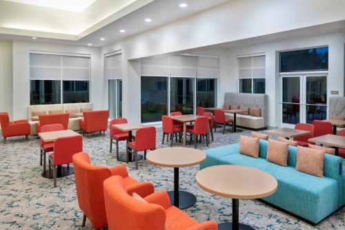 a hotel lobby with tables and chairs and windows at Hilton Garden Inn Orlando International Drive North in Orlando