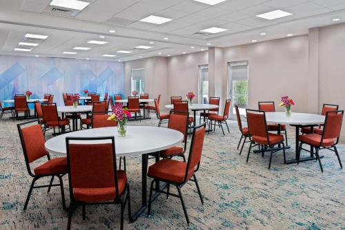 a conference room with tables and chairs and flowers on them at Hilton Garden Inn Orlando International Drive North in Orlando