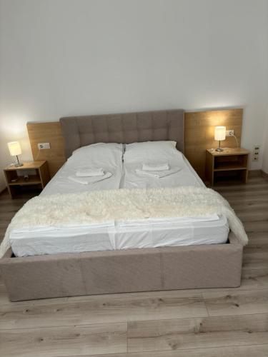 a large bed in a bedroom with two night tables at Апартамент Евксиновград, една спалня - безплатен паркинг, Варна in Varna City