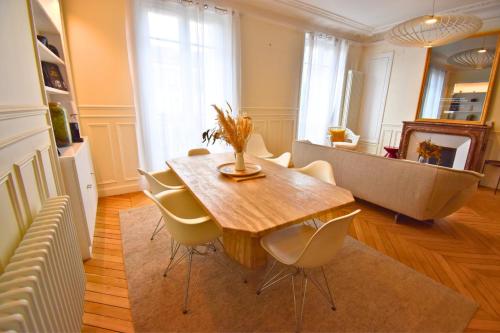 une salle à manger avec une table et des chaises en bois dans l'établissement Paris Pantin Prestige, à Pantin