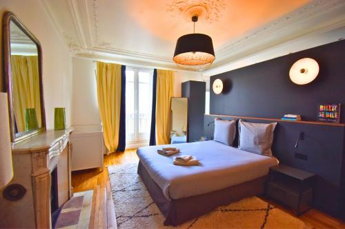 a bedroom with a bed with a blue wall at Paris Pantin Prestige in Pantin