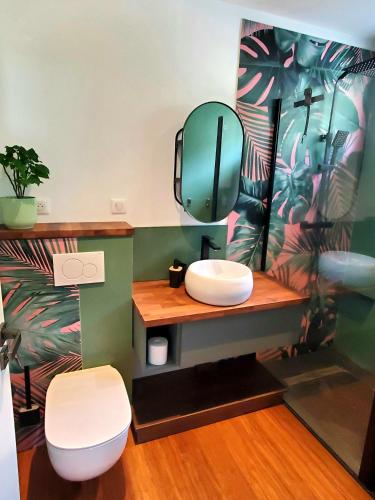 une salle de bain avec des toilettes blanches et un miroir dans l'établissement Au calme du Golf - Appartement Chic 5 étoiles, à Hossegor