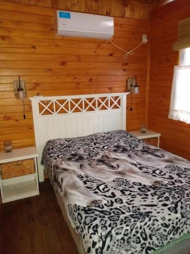 a bedroom with a bed in a room with wooden walls at Cabañas Pa ke mas in Punta Indio