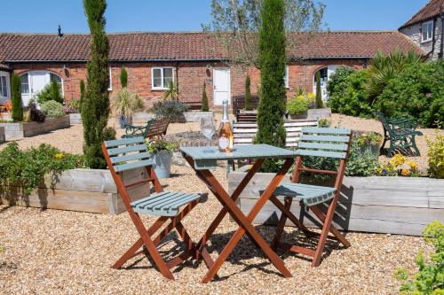 a picnic table and chairs in a garden at Kibbletree Cottage in Bridlington