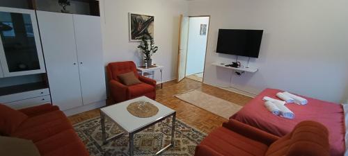 a living room with a red couch and a tv at Apartment Mia in Sarajevo