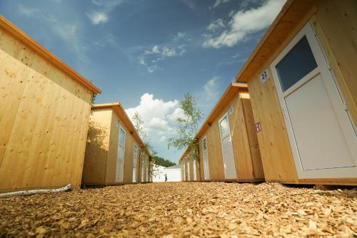 a row of wooden buildings with white doors at LivinGood by PartyStadl in Flatschach