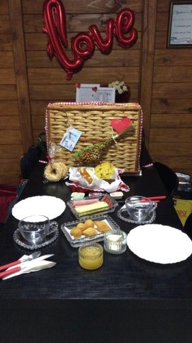 a table with a basket of food and plates on it at Cabana Amor Perfeito in Barracão