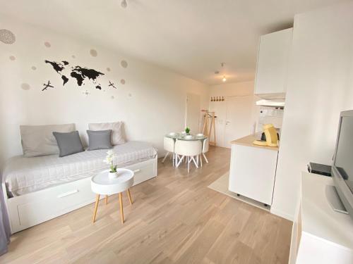 une petite chambre avec un lit et une cuisine dans l'établissement Grand Studio Montévrain - Disneyland RER A, à Montévrain