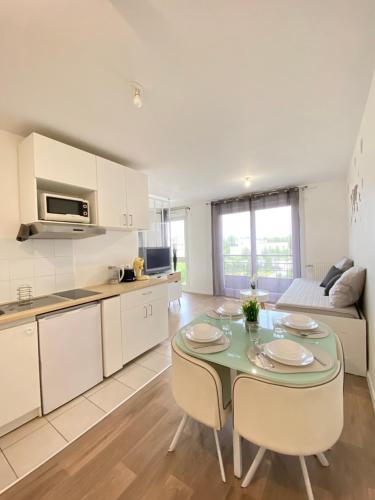 une cuisine et un salon avec une table et des chaises dans l'établissement Grand Studio Montévrain - Disneyland RER A, à Montévrain