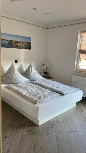 a large white bed in a white room at David´s Apartment in Meckenbeuren
