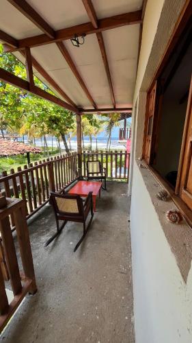 a covered porch with a bench and a table at Casa de playa Los Moncada in León