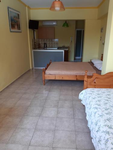 a bedroom with two beds and a kitchen at Stroubis Studios I in Megás Limniónas