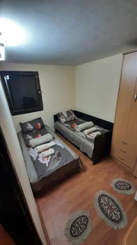 a room with two beds and a flat screen tv at Vikendica Aleksandar in Čačak