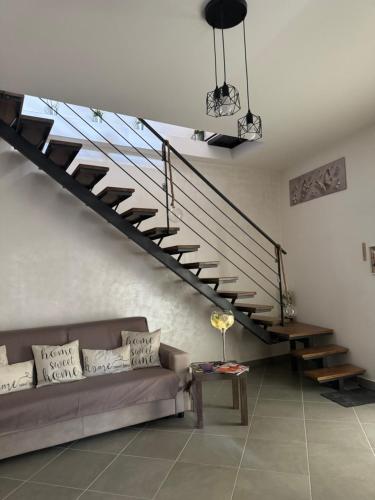 a living room with a couch and a staircase at La farfalla del vicolo in Larino