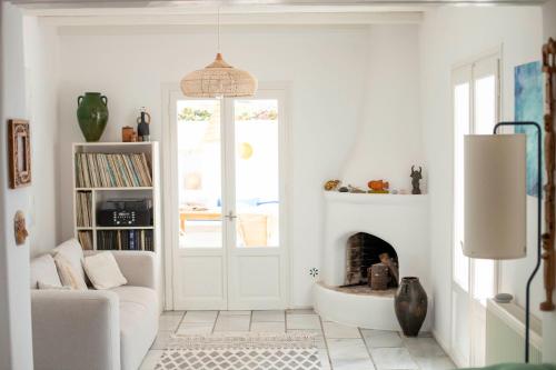 een woonkamer met open haard en een bank bij Stylish Cycladic Family Villa with Private Gardens - Villa Botanica in Kampos Paros