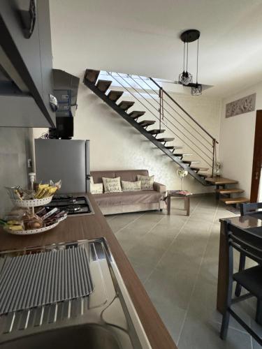 a kitchen with a couch and a spiral staircase at La farfalla del vicolo in Larino