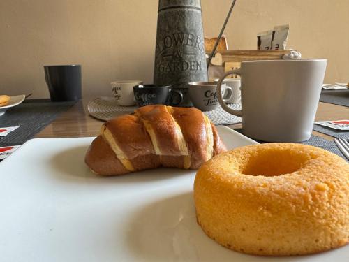 two donuts sitting on a plate on a table at La farfalla del vicolo in Larino