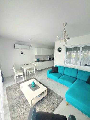 a living room with a blue couch and a table at Great seaview appartments in Thalassa in Vokolidha