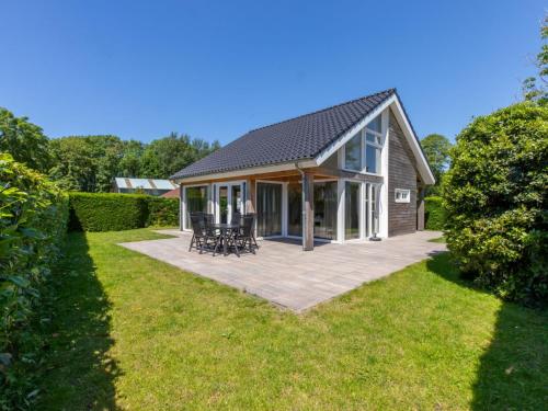 a detached house with a patio and lawn at Holiday Home near Beach Burgh-Haamstede in Burgh Haamstede