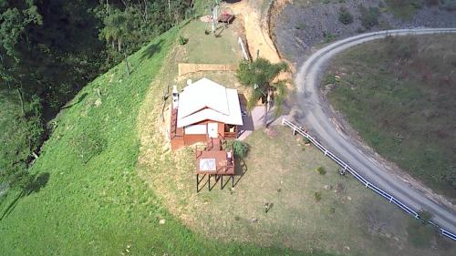 an overhead view of a house on a hill with a road at Cabana Amor Perfeito in Barracão