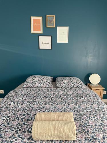 une chambre avec un lit avec un mur bleu dans l'établissement Oustau Aix, à Aix-en-Provence