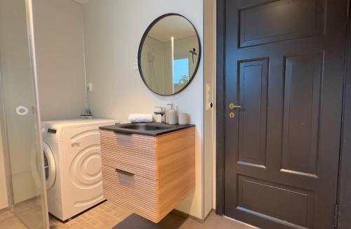 a bathroom with a sink and a mirror next to a door at Reine Superior Panorama House in Reine
