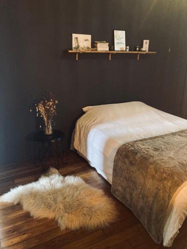 une chambre avec un lit et un tapis au sol dans l'établissement Villa des rosiers, à Saint-Ouen