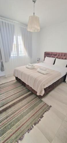 a large bed in a bedroom with a large window at Great seaview appartments in Thalassa in Vokolidha
