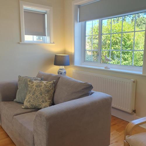 a living room with a couch and two windows at Panorama House - 400m from Sandbanks beach in Sandbanks