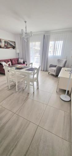 a white living room with a table and a couch at Great seaview appartments in Thalassa in Vokolidha